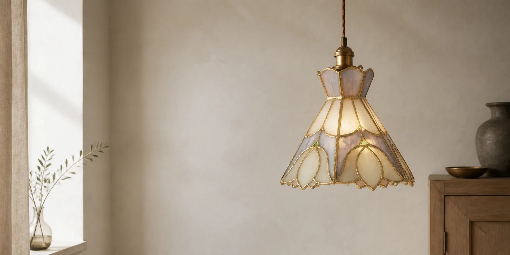 Lavender and cream stained glass pendant glowing in a warm, limewashed interior.